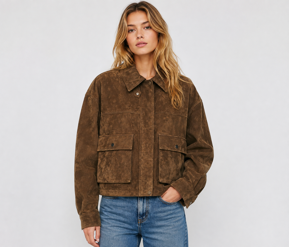 Woman wearing an oversized brown suede bomber jacket with blue jeans