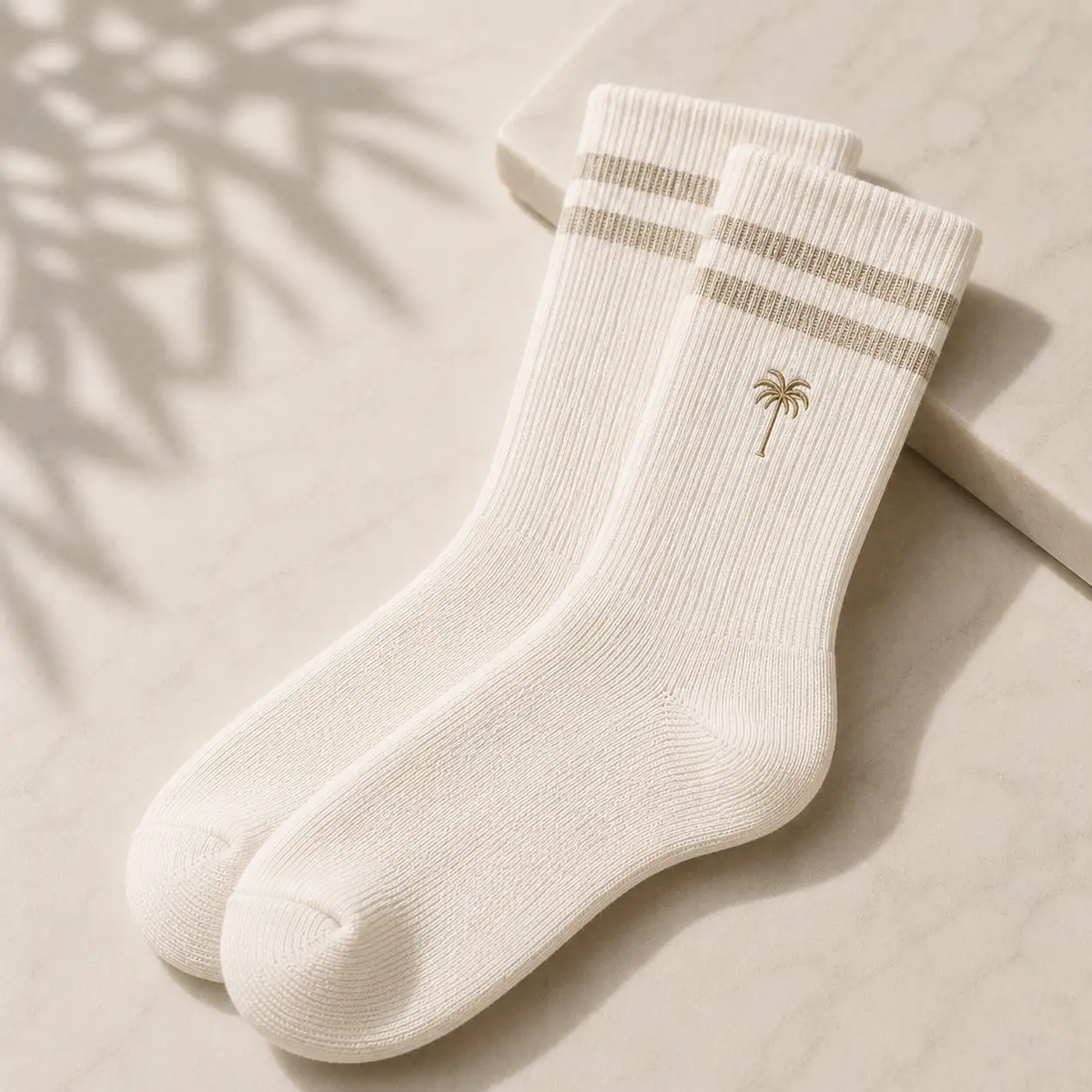 Neutral beige fashion accessories arranged on soft fabric